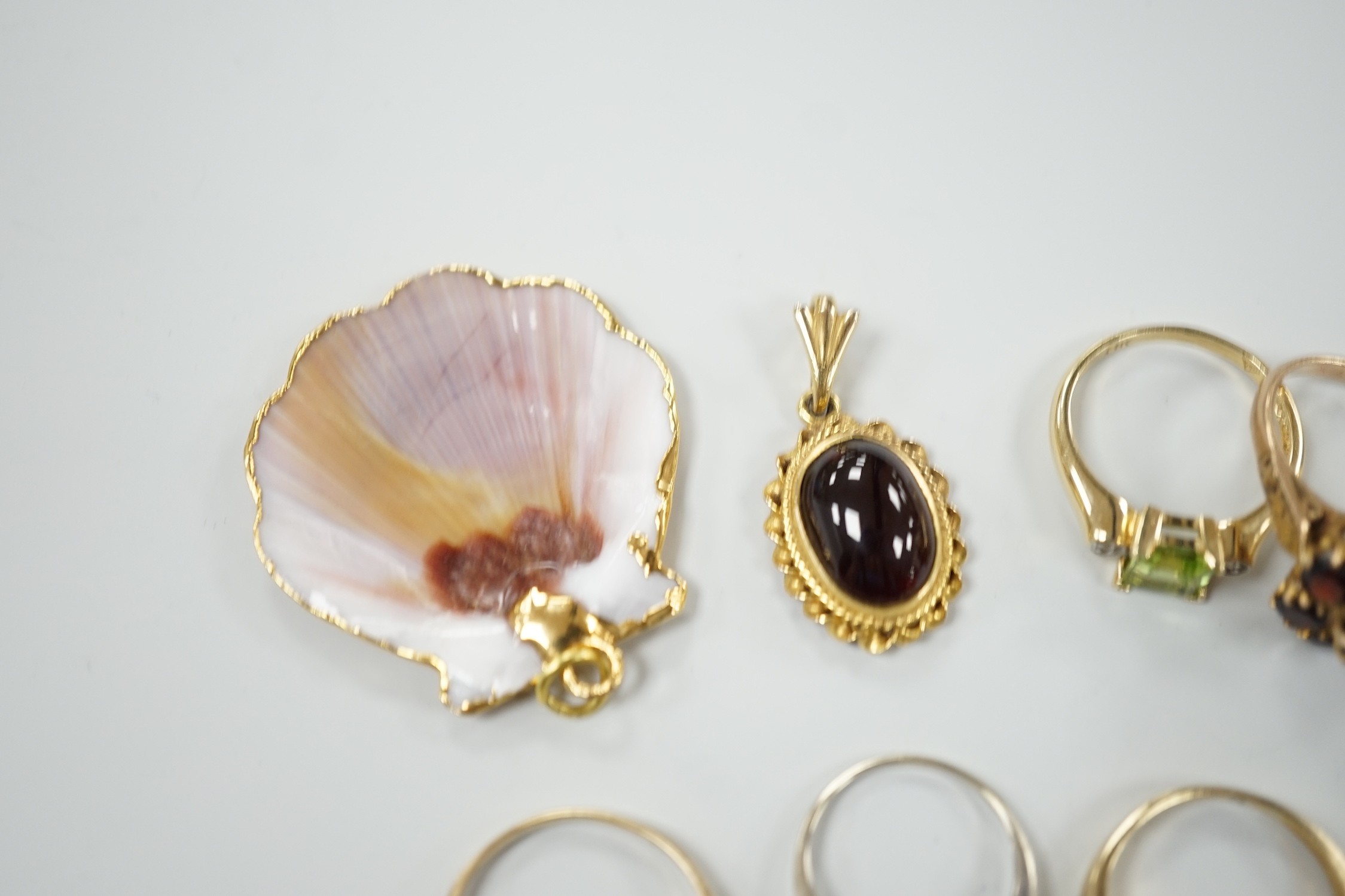 A 9ct and garner cluster set dress ring, size M, gross 4.9 grams, two yellow or white metal and diamond set rings, including half eternity and a yellow metal and garnet set half hoop ring, gross 8.8 grams, a 14k, single